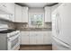 The kitchen has white cabinets and appliances, and a lovely view out of the window at 2696 Dodson Dr, East Point, GA 30344