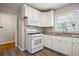 The kitchen features white cabinets and appliances, granite countertops and a view from the window at 2696 Dodson Dr, Atlanta, GA 30344