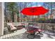 Relaxing back deck with a vibrant red umbrella, outdoor dining set, and cozy cushioned seating at 3222 Pagoda Trce, Lawrenceville, GA 30043