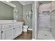 Stylish bathroom features a double vanity, a tiled shower, and wood-look floors at 3222 Pagoda Trce, Lawrenceville, GA 30043