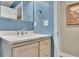 This cozy bathroom features blue walls, a white marble countertop, and a framed painting at 3222 Pagoda Trce, Lawrenceville, GA 30043