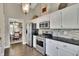 View of the kitchen with white cabinets, stainless steel appliances, and black countertop at 3222 Pagoda Trce, Lawrenceville, GA 30043