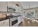 Kitchen with stainless steel appliances, white cabinets, and view to a dining area at 3222 Pagoda Trce, Lawrenceville, GA 30043