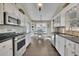Kitchen with white cabinets, stainless steel appliances, granite countertops, and view to the dining area at 3222 Pagoda Trce, Lawrenceville, GA 30043