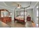 Spacious main bedroom features a four-poster bed, ceiling fan, and wood-look floors at 3222 Pagoda Trce, Lawrenceville, GA 30043
