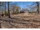 View of the backyard and home featuring multi-level decks, patio, and mature trees at 7025 Bavarian Wood Pl, Buford, GA 30518