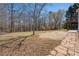Landscaped backyard with grass, trees, and a stone pathway leading to the back of the house at 7025 Bavarian Wood Pl, Buford, GA 30518