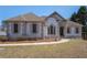 Lovely one-story home with detailed stone accents, complemented by mature landscaping and a welcoming pathway at 7025 Bavarian Wood Pl, Buford, GA 30518