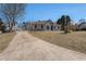 Picturesque view of a well-maintained home on a large lot featuring a long driveway and lush green lawn at 7025 Bavarian Wood Pl, Buford, GA 30518
