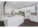 Bright white kitchen features a large island with modern sink and stainless steel faucet, plus stainless steel appliances at 7025 Bavarian Wood Pl, Buford, GA 30518