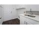 Laundry room with white cabinets, granite countertop, and tile backsplash at 7025 Bavarian Wood Pl, Buford, GA 30518