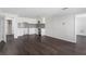 Open-concept living space with updated kitchen, white cabinets, and hardwood floors at 7025 Bavarian Wood Pl, Buford, GA 30518