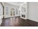 Elegant living room featuring a cozy fireplace, hardwood floors, and large windows for natural light at 7025 Bavarian Wood Pl, Buford, GA 30518