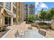 Outdoor patio with seating area, lush landscaping, and a view of the apartment building at 711 Cosmopolitan Ne Dr # 523, Atlanta, GA 30324