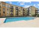 Outdoor swimming pool surrounded by a modern apartment building under a bright blue sky at 711 Cosmopolitan Ne Dr # 523, Atlanta, GA 30324