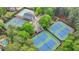 Aerial view of tennis courts, a pool, and a clubhouse surrounded by lush greenery at 10835 Tuxford Dr, Alpharetta, GA 30022