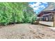 Large backyard featuring a wooden porch and ample green space with lush trees at 10835 Tuxford Dr, Alpharetta, GA 30022