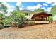 Expansive backyard featuring a covered patio, lush greenery, and mature trees providing ample shade at 10835 Tuxford Dr, Alpharetta, GA 30022