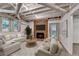 Finished basement showcasing a brick fireplace, exposed beams, and comfortable seating area at 10835 Tuxford Dr, Alpharetta, GA 30022