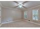 Bright bedroom with neutral colors, ceiling fan, carpet floors, and windows with shutters at 10835 Tuxford Dr, Alpharetta, GA 30022