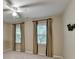 Comfortable bedroom with two windows, neutral walls, a ceiling fan, and plush carpeting at 10835 Tuxford Dr, Alpharetta, GA 30022