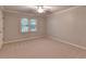 This is a bedroom with carpet, window, ceiling fan, and a neutral color palette, perfect for relaxation and personalization at 10835 Tuxford Dr, Alpharetta, GA 30022