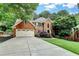 Classic brick home with a three-car garage, well-manicured lawn, and inviting curb appeal at 10835 Tuxford Dr, Alpharetta, GA 30022