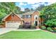 Beautiful brick home featuring a manicured lawn, two-car garage, and mature trees at 10835 Tuxford Dr, Alpharetta, GA 30022