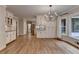 Bright eat-in kitchen features hardwood floors, white cabinets, granite countertops and a decorative chandelier at 10835 Tuxford Dr, Alpharetta, GA 30022