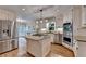 Open kitchen features stainless appliances, granite countertops, a center island, and hardwood floors at 10835 Tuxford Dr, Alpharetta, GA 30022