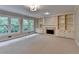 Cozy living room with built-in bookcases, a fireplace, plush carpet and natural light from large windows at 10835 Tuxford Dr, Alpharetta, GA 30022