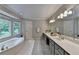 Luxurious main bathroom with soaking tub, double vanity, and large window at 10835 Tuxford Dr, Alpharetta, GA 30022