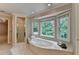 Elegant bathroom featuring a large soaking tub, tile flooring, and a glass-enclosed shower at 10835 Tuxford Dr, Alpharetta, GA 30022