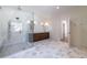 Bathroom featuring a glass shower, double vanity with marble countertop, and stylish gray tile floors and open doorway at 585 Sherwood Ne Rd, Atlanta, GA 30324