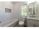 Bright bathroom featuring tiled walls, modern fixtures, and a window offering natural light at 585 Sherwood Ne Rd, Atlanta, GA 30324