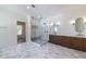 Bathroom featuring a glass shower, double vanity with marble countertop, and stylish gray tile floors and open doorway at 585 Sherwood Ne Rd, Atlanta, GA 30324