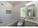 Clean bathroom features a tub/shower combo with tiled walls, a modern vanity and a built-in wall shelf at 585 Sherwood Ne Rd, Atlanta, GA 30324