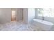 Bathroom showcasing a freestanding tub by a window and an open doorway to a large dressing area at 585 Sherwood Ne Rd, Atlanta, GA 30324