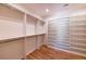 This walk-in closet features custom shelving, hanging racks, and beautiful wood floors at 585 Sherwood Ne Rd, Atlanta, GA 30324
