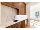 Kitchen with wood cabinets, marble backsplash, and sink at 585 Sherwood Ne Rd, Atlanta, GA 30324