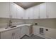 Laundry room with white cabinets, marble countertops, and a stainless steel sink at 585 Sherwood Ne Rd, Atlanta, GA 30324