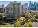Stunning aerial view of high-rise buildings surrounded by mature trees and city skyline and a pool at 700 Park Regency Ne Pl # 803, Atlanta, GA 30326