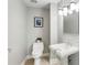 A classic powder room featuring a pedestal sink, stylish lighting and fixtures, and neutral tones at 700 Park Regency Ne Pl # 803, Atlanta, GA 30326