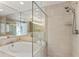 This bathroom features a modern walk-in shower with glass door, a luxurious tub, and neutral tile finishes at 700 Park Regency Ne Pl # 803, Atlanta, GA 30326