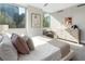 Light-filled bedroom features a dresser, chair, and large window, with artistic wall decor creating an inviting atmosphere at 700 Park Regency Ne Pl # 803, Atlanta, GA 30326