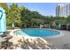 Beautiful pool area showcasing a large pool, lounge chairs, and a view of the building and surrounding trees at 700 Park Regency Ne Pl # 803, Atlanta, GA 30326