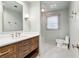 Well-lit bathroom showcasing a vanity with drawers, a toilet, and a framed mirror at 2411 Mitchell Ne Rd, Marietta, GA 30062