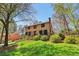 Traditional two-story brick home on a lush lot with mature trees and green grass in a suburban setting at 2411 Mitchell Ne Rd, Marietta, GA 30062