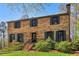 Charming two-story brick home featuring manicured landscaping and dark shutters on a sunny day at 2411 Mitchell Ne Rd, Marietta, GA 30062