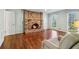 Cozy living room with a brick fireplace, hardwood floors, and large windows letting in natural light at 2411 Mitchell Ne Rd, Marietta, GA 30062